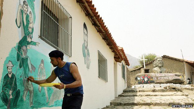 Cuban doctor Carlos Alfredo Garcia paints a mural depicting Che Guevara's guerrilla epics on the wall of a medical clinic on 3 October 2007 in La Higuera, Bolivia.