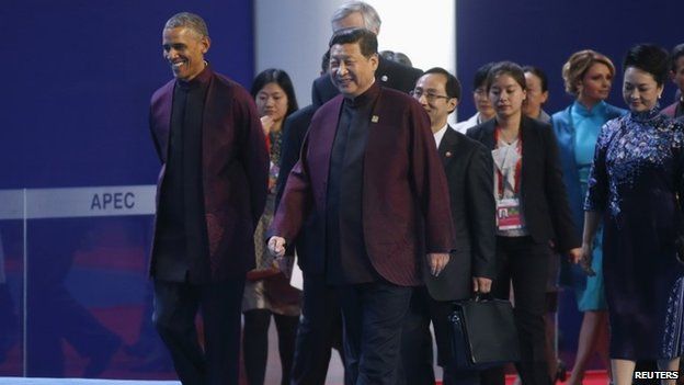US President Barack Obama and Chinese President Xi Jinping walk ahead of other leaders as they arrive for the APEC Summit family photo in Beijing 10 November 2014
