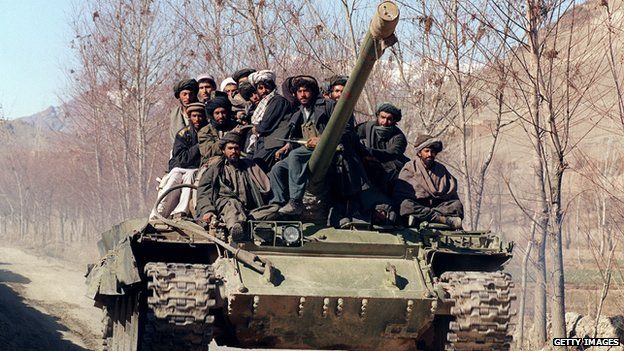 A group of Islamic militants, members of the Afghan religious Taliban militia, move toward the front line on a tank, near Kabul, on February 18, 1995