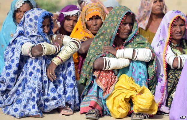 Pakistani villagers wait to receive relief supplies outside a military camp in Mithi, the capital of Tharparkar district, some 300 kilometres from Karachi on 11 March 2014.