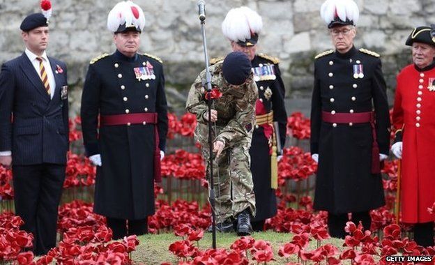 Military cadet Harry Alexander Hayes places the last ceramic poppy in the moat of the Tower of London to mark Armistice Day on 11 November 2014