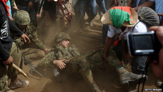 Members of the Nasa indigenous group drag Colombian army sergeant Rodrigo Garcia out of his military post on Mount Berlin, in Toribio on 17 July , 2012
