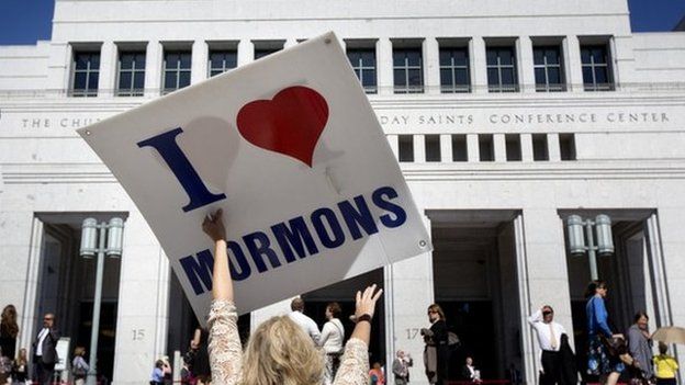 A women holds up a I love Mormon sign in Salt Lake City