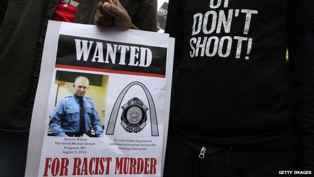 Demonstrators holds a sign on October, 11 2014 in St. Louis, Missouri, as they protest the shooting death of Michael Brown.