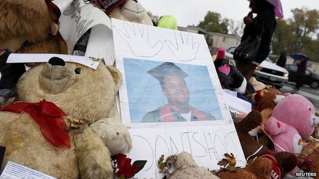 A woman walks by a memorial set up for Michael Brown in Ferguson, Missouri, October 10, 2014. Brown was killed by Ferguson police officer Darren Wilson.