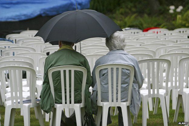 Elderly couple sitting on plastic chairs