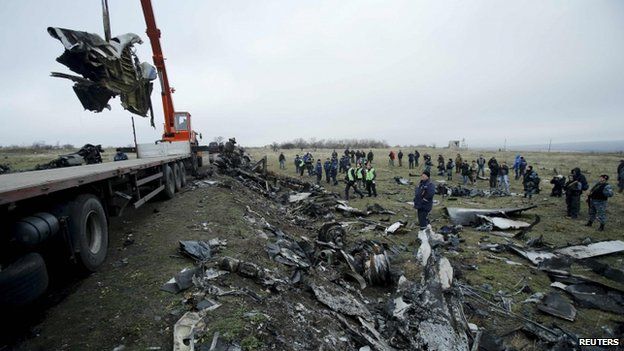 A crane carries wreckage of the Malaysia Airlines Boeing 777 plane (flight MH17) at the site of the plane crash near the settlement of Grabove in the Donetsk region, 16 November 2014
