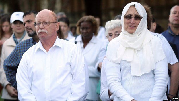 Ed (L) and Paula Kassig listen to a speaker during a prayer vigil for their son in October