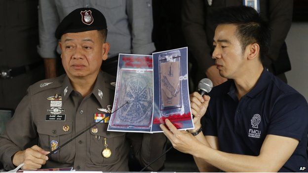Thai police officers show pictures of a tattooed human skin during a press conference at Bangpongpang police station in Bangkok, Thailand, Monday, 17 Nov 2014