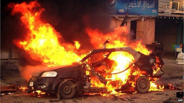 A blaze engulfs a car at the scene of an explosion in the Shiite Muslim Al-Amin district of Baghdad, 8 December 2013