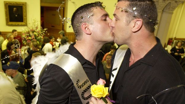 David Rudeurick, 34, center, and Michael Hight, 39, both of Somerville, Mass., kiss inside City Hall in Cambridge, Mass., on Sunday, May 16, 2004