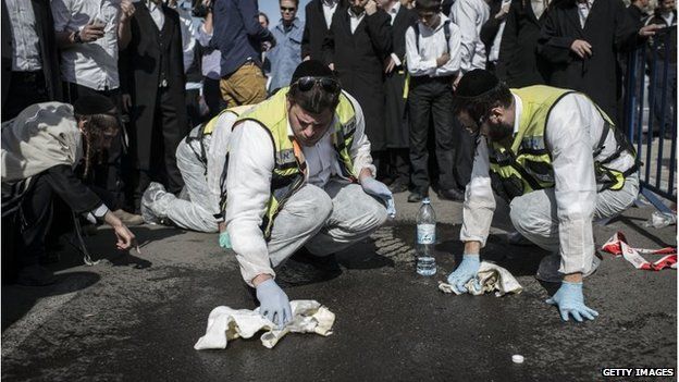 Israeli emergency personnel clean the site outside a synagogue