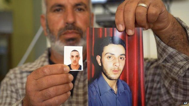 A relative with photos of Uday (left) and Ghassan Abu Jamal, 18 Nov