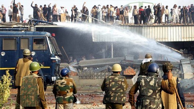 Indian police use water cannon to scatter supporters of self-styled guru Baba Rampal during an attempt to storm Rampal"s compound, Hisar, Haryana, India, 18 November 2014.