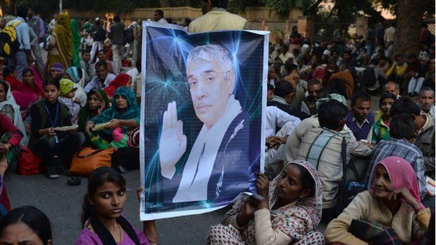 Devotees of Indian self-styled "godman", Rampal Maharaj hold a poster of his image during a dharna - non-violent sit-in protest