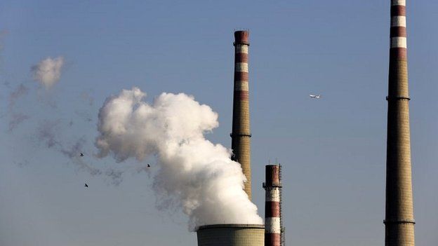 A passenger airliner and birds fly past a coal-fired power plant in Beijing, China - 13 November 2014