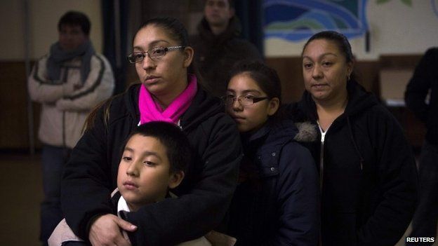 Undocumented immigrant Alejandra Mota, holds her son, a US citizen, as they watch President Barack Obama announce executive action on immigration, at the West Kensington Ministry church, in Philadelphia, November 20, 2014.