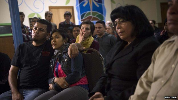 Undocumented immigrant Angela Navarro and her husband Ermer Fernandez (L), along with other immigrants and supporters, watch U.S. President Barack Obama speak 20 November 2014