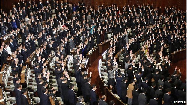 Japanese Lower House lawmakers raise their hands and shouts "banzai" (cheers) after the dissolution of lower house was announced at the Parliament in Tokyo 21 November 2014.