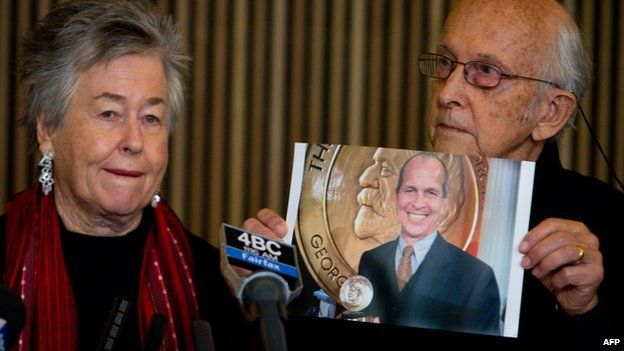 Juris Greste (R) displays a picture of his son, jailed Australian Al-Jazeera journalist Peter Greste, next to his wife Lois (L) during a press conference in Brisbane on June 24, 2014.