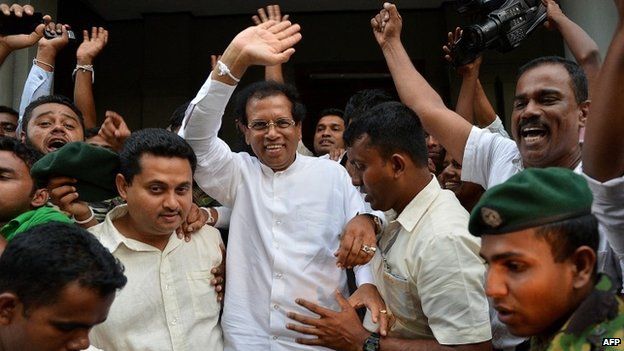 Maithripala Sirisena (C) waves to supporters in Colombo shortly after defecting from the ruling party and declaring himself as the common opposition candidate to challenge President Mahinda Rajapaksa (21 November 2014)