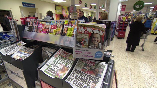 Newspapers and magazines on display in a Tesco store