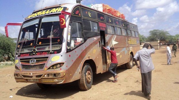 Rescue workers walk near a Nairobi-bound bus that was ambushed by militants near Kenya's border with Somalia - 22 November 2014