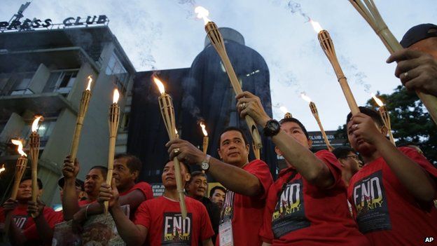 Journalists in Manila carry torches ahead of commemorations of the Maguindanao massacre. Photo: 21 November 2014