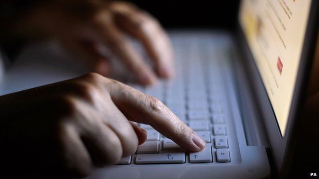 Hands typing at a computer