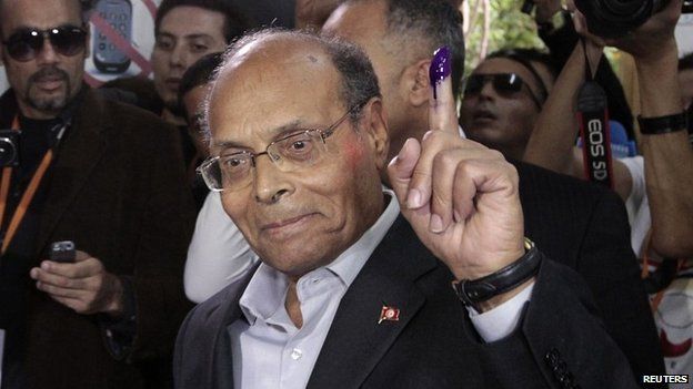 Tunisian President Moncef Marzouki shows his ink-stained finger after voting in Tunisia's presidential election - 23 November 2014