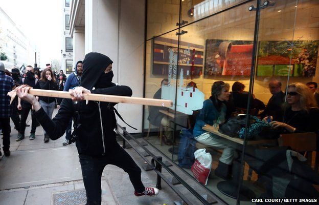 A protester about to hit a window of Starbucks with a piece of wood, 19 November 2014
