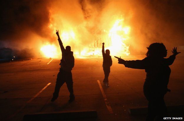 Demonstrators celebrate as a business burns in Ferguson, 24 November