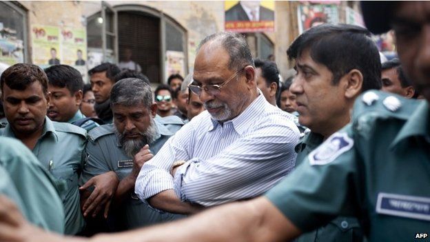 Bangladesh former minister Abdul Latif Siddique (C) is flanked by police officers at court after turning himself in in Dhaka