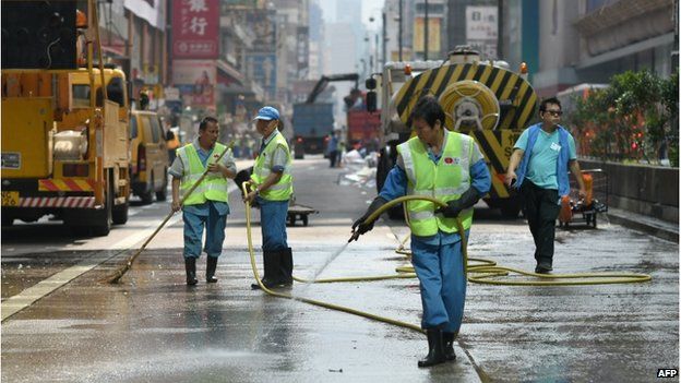 Workers spray a road, previously occupied by pro-democracy protesters, after police completed their clearance of a major protest site in the Mongkok district of Hong Kong on 26 November 2014