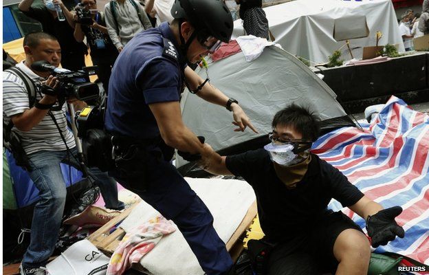 A riot police officer detains a pro-democracy protester who refuses to leave during the clearance of a protest site on the main Nathan Road at Mongkok district in Hong Kong November 26, 2014