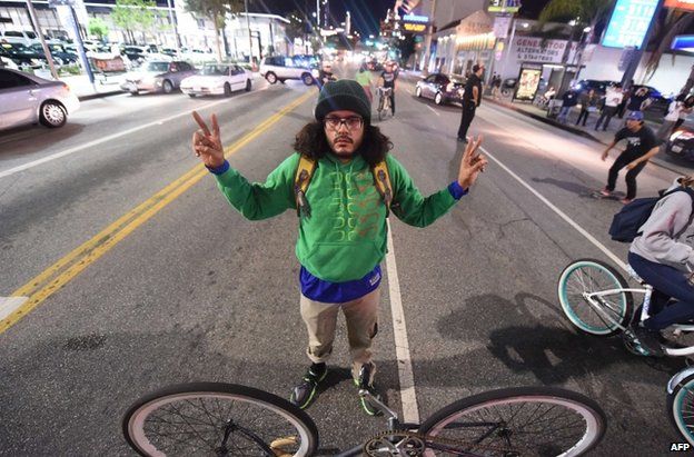 A cyclist blocks a road in Los Angeles, 25 November