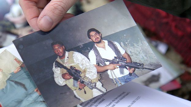 A photograph showing Sayid holding a US rifle