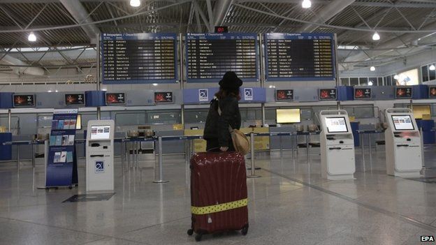 A commuter looks at a departure board during a strike in Greece