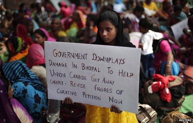 A child of a victim of the Bhopal gas tragedy, a gas leak from a Union Carbide pesticide plant that killed at least 3500 people, holds a placard during a sit-in protest in New Delhi November 10, 2014.