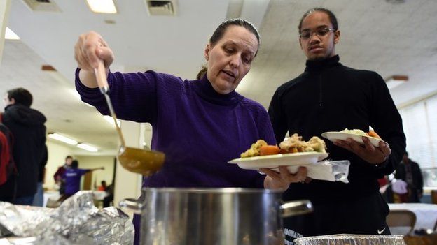 A woman gets a Thanksgiving meal at a church in Ferguson