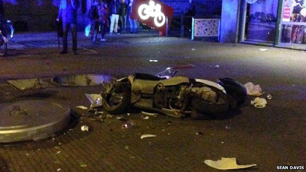 A scooter lies in pieces after a public toilet suddenly emerged from the ground