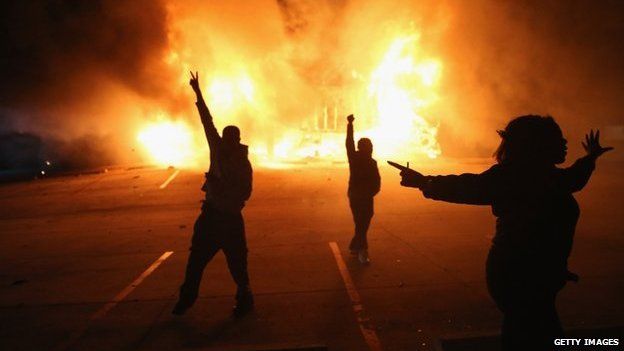 Demonstrators celebrate as a business burns in Ferguson, 24 November