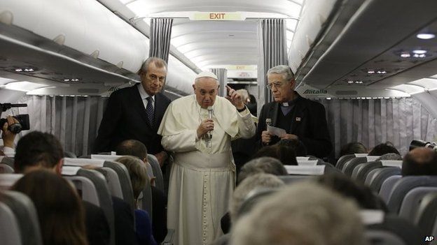 Pope Francis flanked by Vatican spokesman father Federico Lombardi talks to journalists during a press conference aboard the flight towards Rome