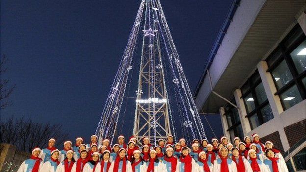 South Korean Christians sing a hymn in front of a Christmas tree atop a military-controlled hill near the tense land border in Gimpo, west of Seoul, on December 21, 2010