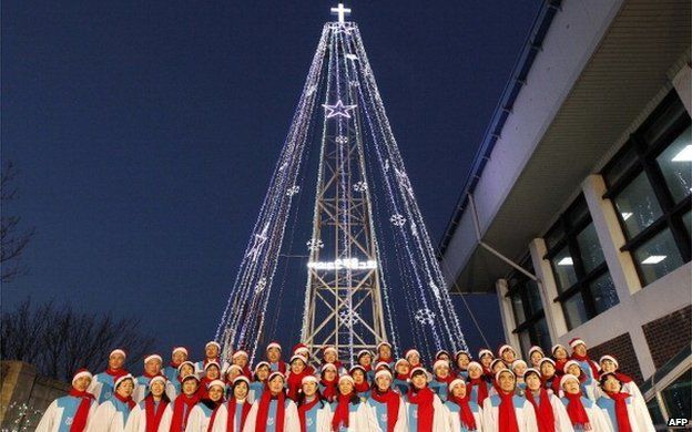 South Korean Christians sing a hymn in front of a Christmas tree atop a military-controlled hill near the tense land border in Gimpo, west of Seoul, on December 21, 2010
