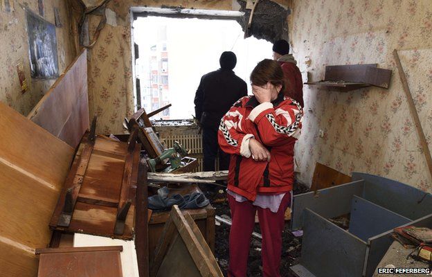 A woman cries after seeing the damage in her neighbor"s flat on December 1, 2014 after it was destroyed by shelling during the night in the Telstilshik district of the eastern Ukrainian city of Donetsk