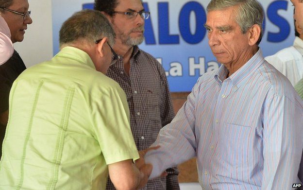 Farc delegate Rodrigo Granda (left) shakes hands with Jorge Enrique Mora (right), a member of the Colombian government's delegation, at Convention Palace in Havana on 3 December 2014.