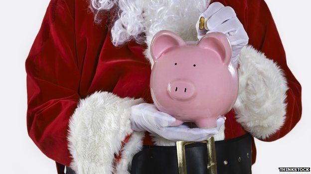 Father Christmas holding a piggy bank