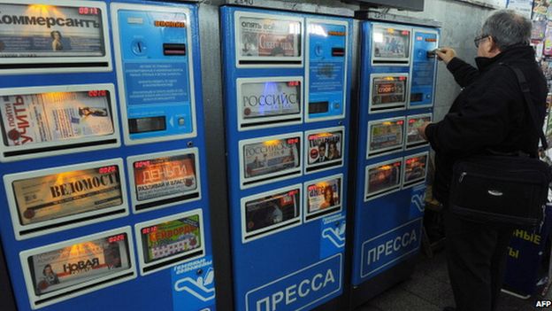 A man buying a newspaper from a self-service machine in Moscow