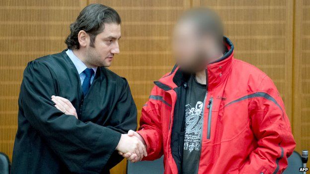 Berisha, to the right, greets his lawyer, Mutlu Guenal, at the court in Frankfurt